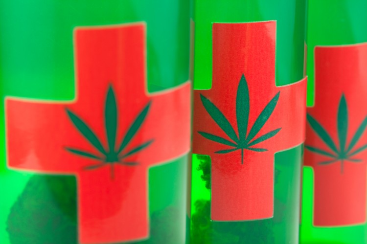 marijuana-buds-in-green-vials-with-red-crosses
